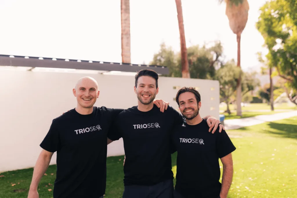 Nathan stands left, Steven in center, Connor right, all in TRIOS&reg; t-shirts outdoors.