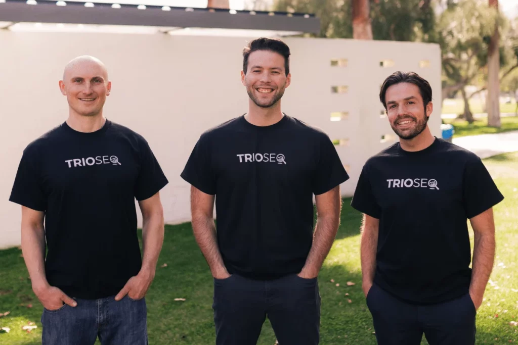 Smiling group with Nathan, Steven, and Connor in branded TRIOS® black t-shirts.